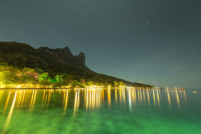 Scenic view of lake against sky at night