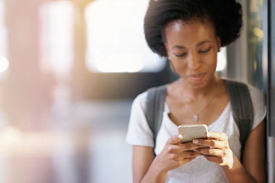 Close-up of student using phone in corridor