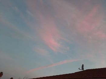 Low angle view of pink rainbow against sky at sunset