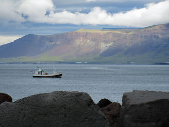 Scenic view of sea and mountains against sky