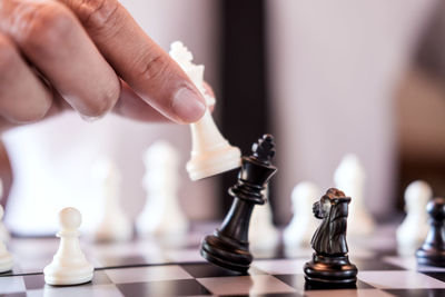 Midsection of businessman playing chess board