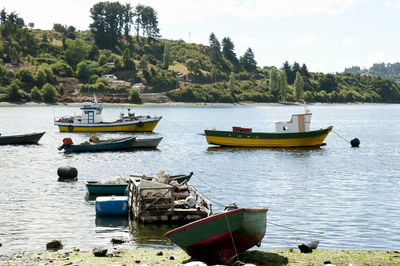 Boats moored in lake against sky