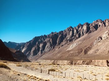 Scenic view of mountains against clear blue sky