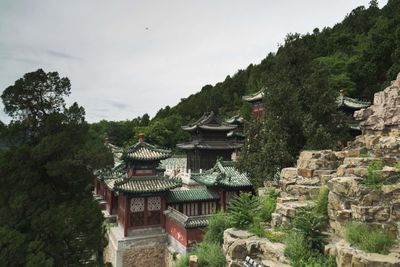 Houses amidst trees and buildings against sky