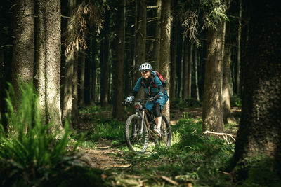 Man riding bicycle on tree trunk