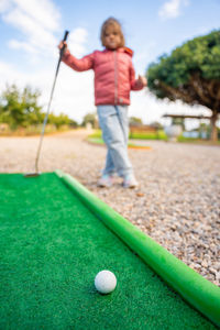 Full length of boy playing golf