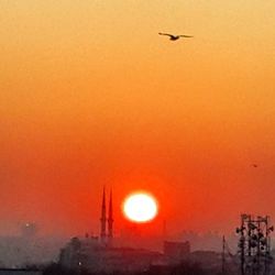 Airplane flying against orange sky