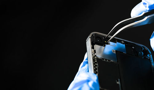 Technician repairing the smartphone's motherboard in the lab with copy space.