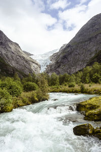 Scenic view of river amidst mountains against sky