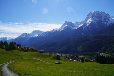 Scenic view of field and mountains against sky