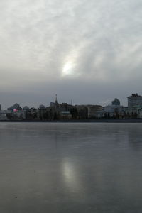 Buildings by sea against sky