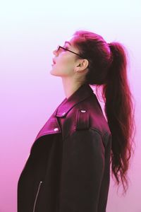 Side view of a young woman looking away against white background