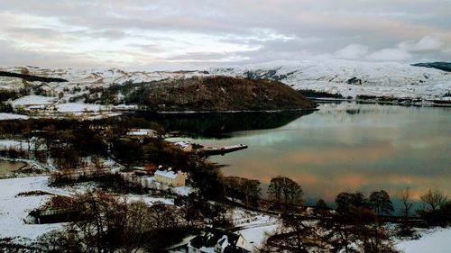 Scenic view of frozen lake by mountains against sky