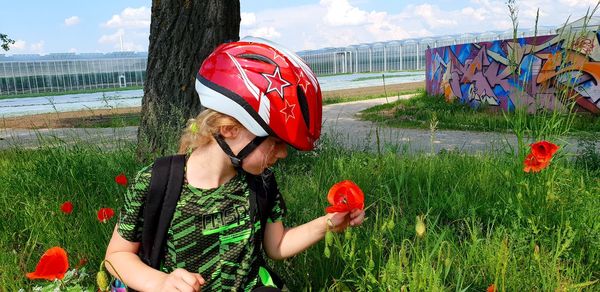 Girl looking at red flowering plants