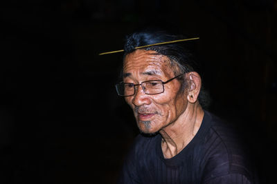 Portrait of man wearing mask against black background