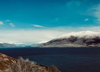 Scenic view of snowcapped mountains against blue sky