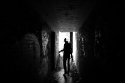 Rear view of silhouette man walking in tunnel