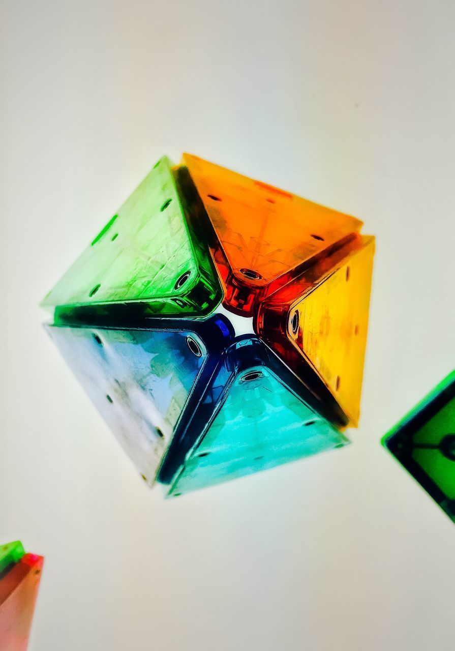 CLOSE-UP OF MULTI COLORED PENCILS ON GLASS TABLE