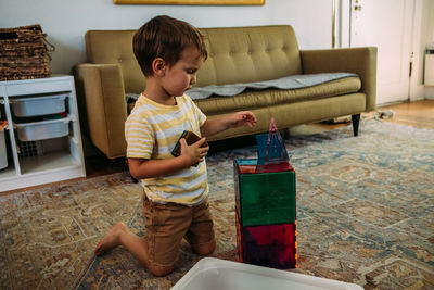 Center portrait of young boy building a tower with magnet tiles