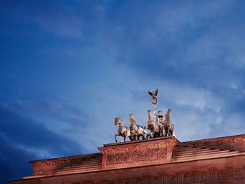 Low angle view of statue on building against sky