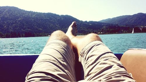 Low section of man relaxing in lake