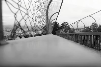 Fence by wall against sky