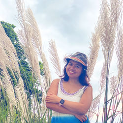 Portrait of smiling woman standing against sky