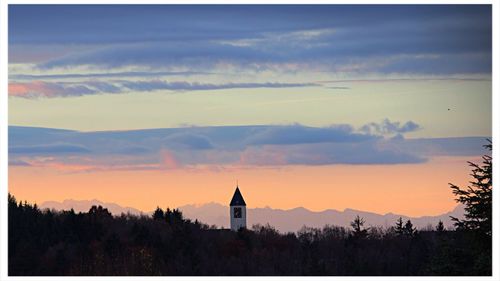 Silhouette of church against cloudy sky