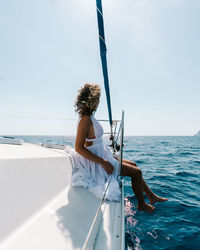 Man on boat in sea against sky