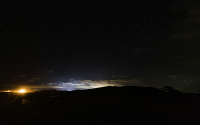 Scenic view of silhouette mountain against sky at night