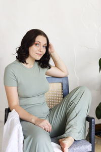 Portrait of young woman sitting on chair