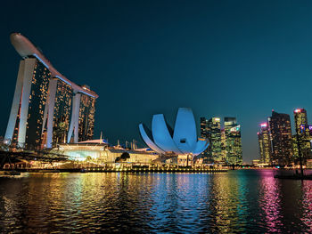 Illuminated city buildings against sky at night