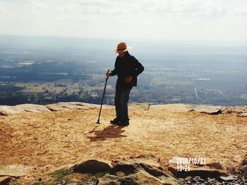 Full length of man standing on landscape against sky