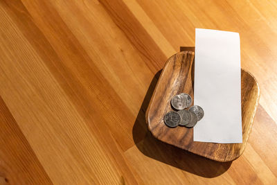 High angle view of coins and paper on table