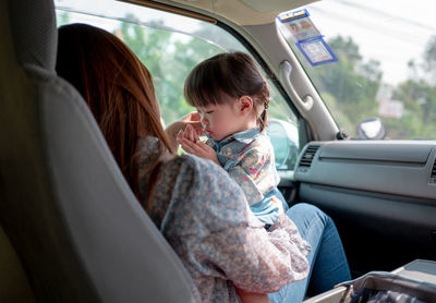 Mother and daughter sitting in car