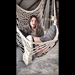 Portrait of smiling woman sitting on hammock