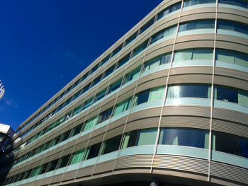 Low angle view of modern building against clear blue sky