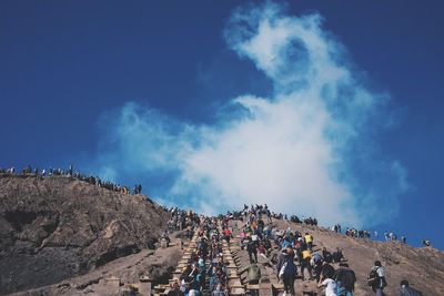 Group of people on rock against sky