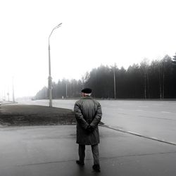 Rear view of man standing on road