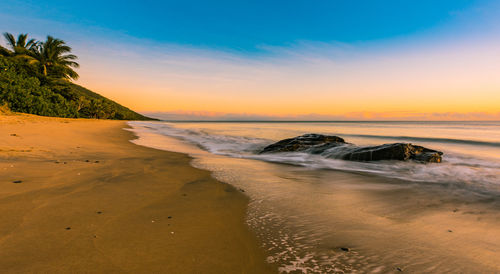 Scenic view of beach against sky during sunset