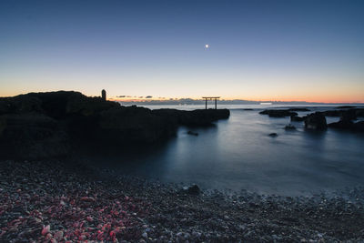 Scenic view of sea against clear sky at sunset