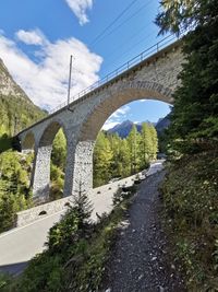 Arch bridge over road against sky