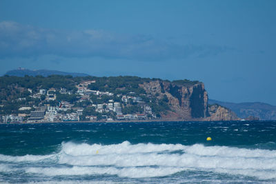 Scenic view of sea by buildings against sky