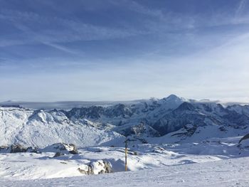 Scenic view of snowcapped mountains against blue sky