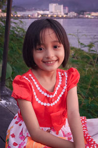 Portrait of a smiling girl sitting outdoors