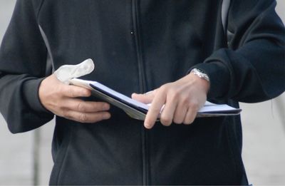 Midsection of man holding mobile phone