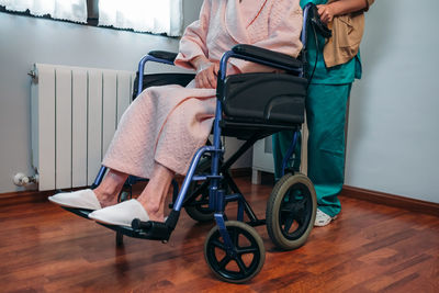 Nurse with senior patient on wheelchair in hospital ward