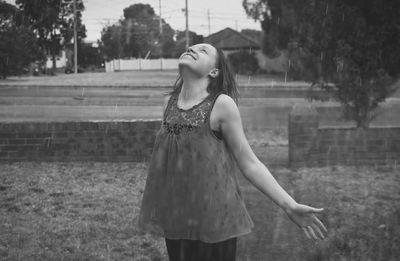 Beautiful woman standing in rain at park