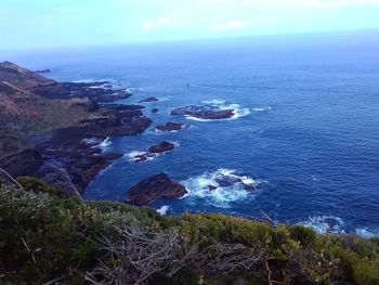 High angle view of rocks by sea against sky