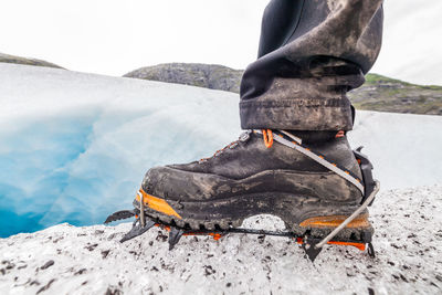 Man standing on snow covered mountain against sky